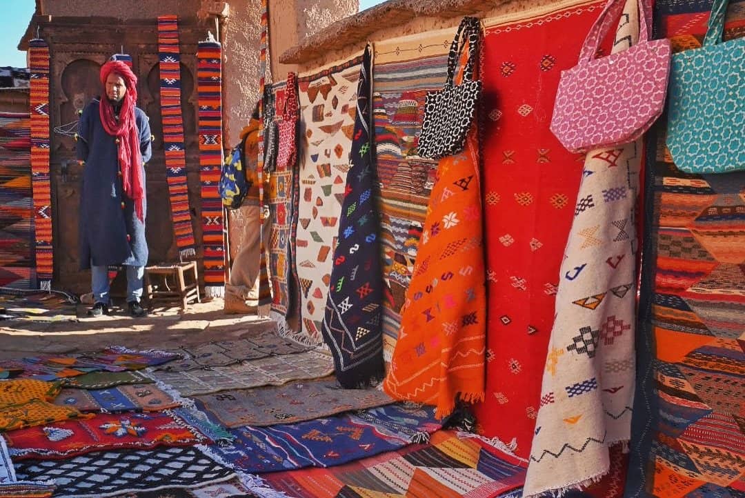 Berber women weaving traditional Moroccan carpets in a village visited during the Fes to Marrakech Tour
