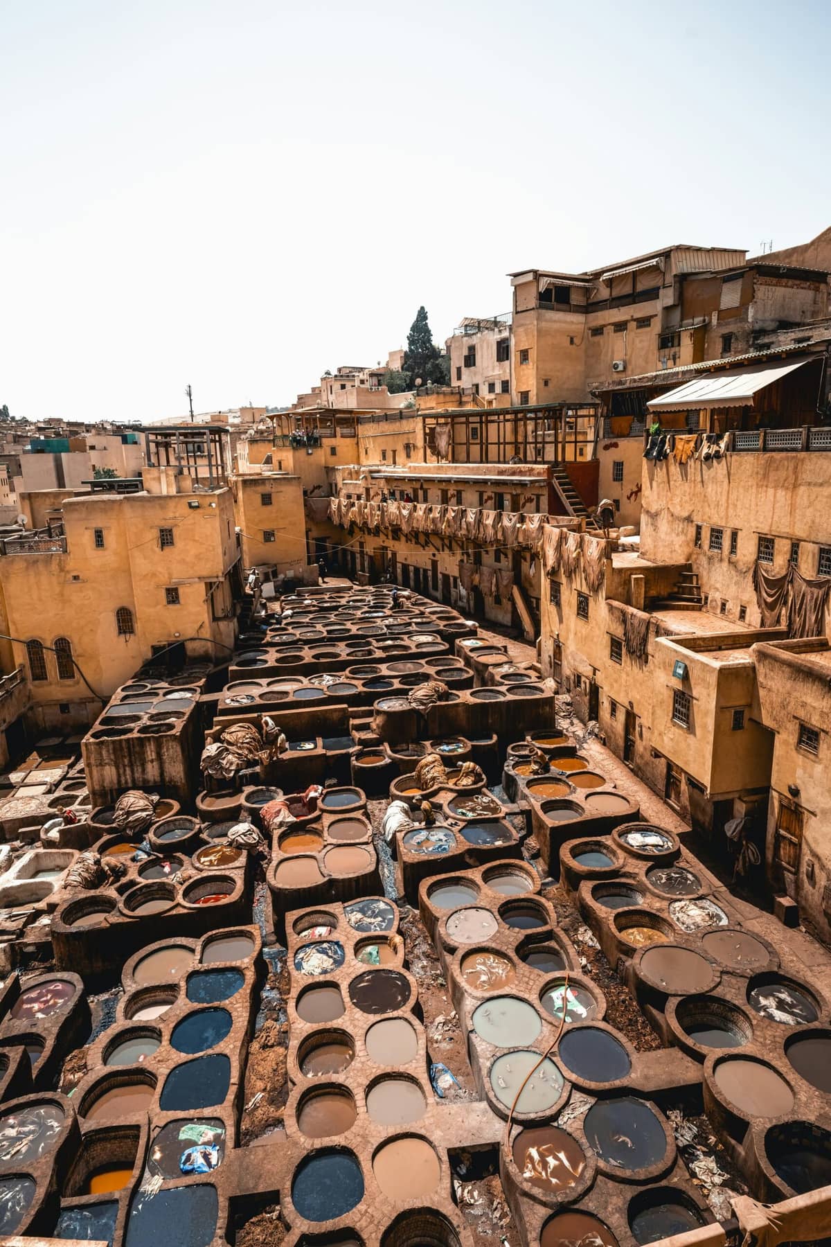 View of the historic Chouara Tannery in Fes Medina, Morocco, featuring traditional leather dyeing vats and centuries-old buildings