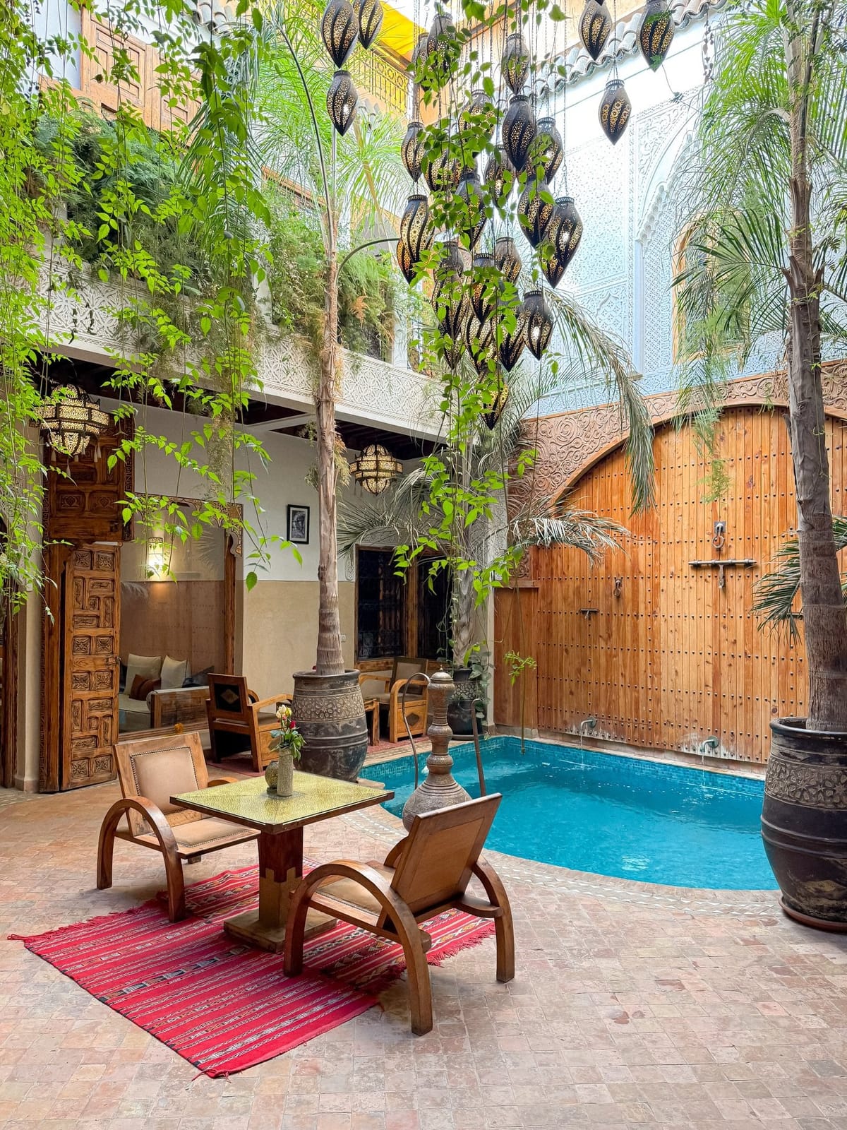 Riads in Morocco featuring a traditional courtyard with a fountain, colorful Moroccan zellige tiles, and decorative arches